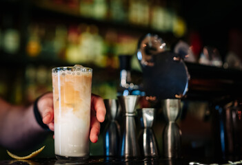 bartender hand hold coffee creamy cocktail in glass in bar