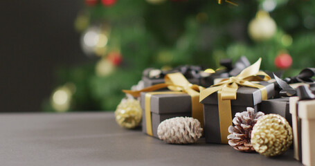 Naklejka na ściany i meble Image of christmas gifts with pine cones and copy space on black background