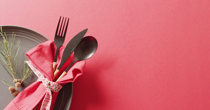 Image of christmas place setting with cutlery and copy space on red background
