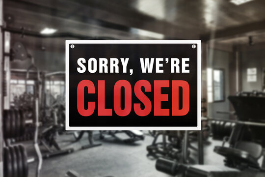 Image of a blurred gym background with closed sign in front.