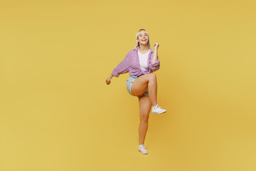 Fototapeta na wymiar Full body young blonde woman 20s wear pink tied shirt white t-shirt doing winner gesture celebrate clenching fists say yes isolated on plain yellow background studio portrait People lifestyle concept