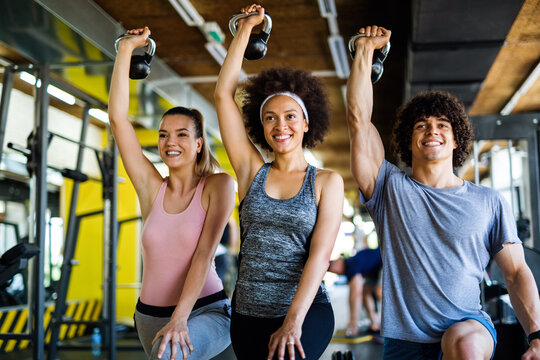 Group of fit people lifting dumbbells during an exercise class at the gym