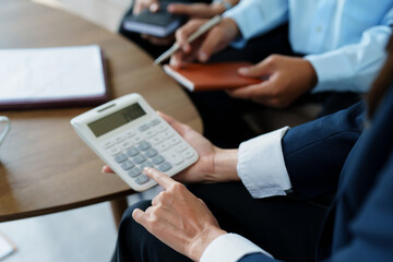 bank employee uses a calculator to calculate loan rates for customers