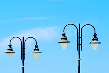 Old-fashioned street lights, vintage street lamps close-up against a blue sky