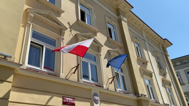 European Union flag and a Polish flag on a bilding of City Council in Przemysl on clear blue sky background