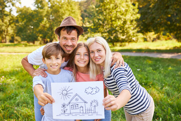 Glückliche Familie mit Zeichnung vom Traumhaus