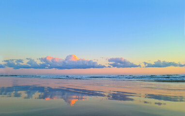 The sky with clouds is amazingly beautiful. Sea sunset in pink and blue colors.