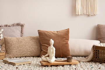 Interior design of meditation living room interior with beige carpet, pillows, macrame and personal...