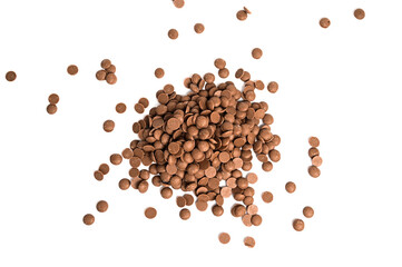 Close up of milk chocolate chips. Scattered chocolate callets isolated on white. Texture of chocolate
