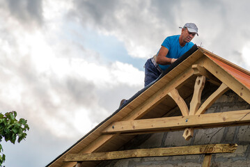 Roofer man roof carpenter working Country house renovation.