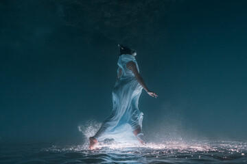 Young pregnant woman poses for an underwater photo session.