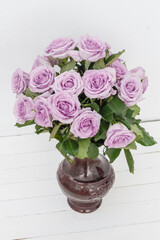 bouquet of beautiful pink roses with water drops in a vase on a white background