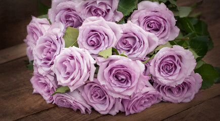 a bouquet of delicate purple roses on a background of dark wooden boards