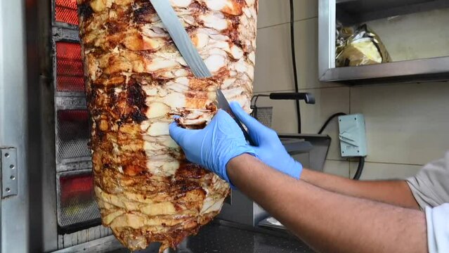 4k: Chef cutting the meat, Preparation of chicken shawarma sandwich, doner kebab, the most popular Arabic-Turkish street food in the world