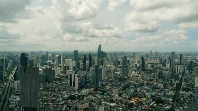 4K Cinematic urban drone footage of an aerial panoramic view of buildings and skyscrapers in the middle of downtown Bangkok, Thailand on a sunny day.