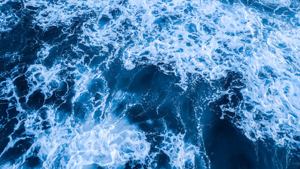 Top view aerial photography white sea foam against the background of the blue sea or ocean....