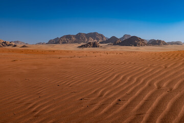 Fototapeta na wymiar Dunes and patterns in the sand in the Wadi Rum desert, sunny day, Jordan