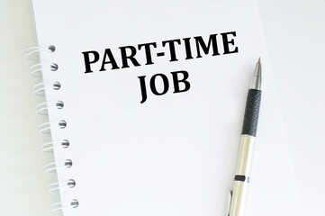 PART-TIME JOB text on a white sheet of notepad on a table next to a pen, a business concept