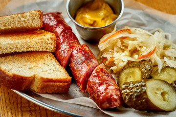 German beer snack - grilled sausage, with sauerkraut and sauce. Close-up, selective focus