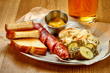 German beer snack - grilled sausage, with sauerkraut and sauce. Close-up, selective focus