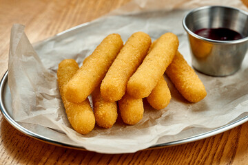 An appetizer for beer - breaded stick mozzarella fries. Close-up, selective focus
