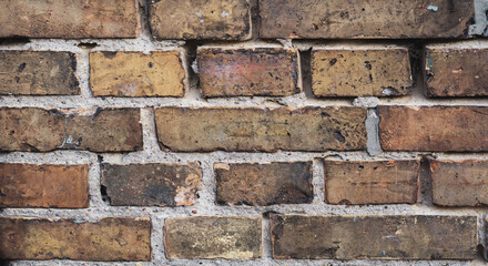 Faded old red brick wall, wide rough vintage texture. Dirty wall with grunge rectangular blocks, close-up, grungy texture.