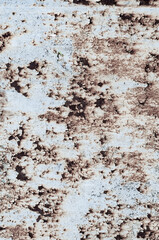 Rusty sheet of metal with peeling faded paint, covered with dust and dirt, grungy texture surface, close-up vintage background.