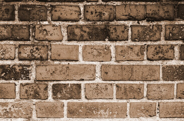 Faded old red brick wall, wide rough vintage texture. Dirty wall with grunge rectangular blocks, close-up, grungy texture of blackened bricks
