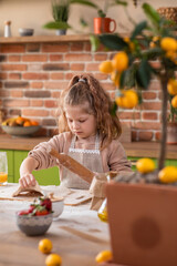 At the modern kitchen island very tired cute girl preparing the dough for a delicious dessert she using the kitchen roller for modelling
