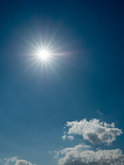 Sun in a blue cloudy sky. Vertical image for design purpose and sky replacement.