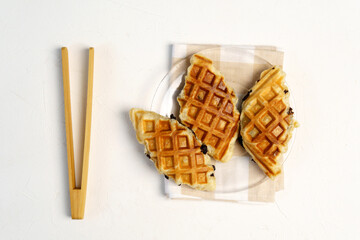 Croffle or Croisant waffle dessert, a marriage between a croissant and a waffle iron. Top view. White background