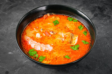 delicious hot traditional tom yam soup on a black background