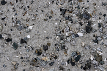 Concrete wall texture with pebbles. Decorative rough concrete surface with white, black and gray stones. Perfect for background and design. Closeup. High resolution.