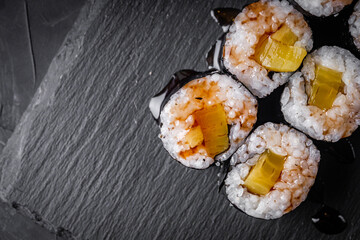 delicious sushi rolls on a black stone background