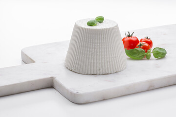 whole ricotta with fresh tomatoes on white marble