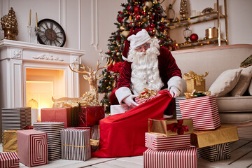 Santa Claus puts presents in his big red bag to wish the children a Merry Christmas.
