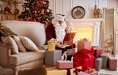 Surprised Santa Claus with a magical glowing gift near beautiful christmas tree.  New year and Merry Christmas , happy holidays concept