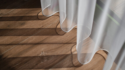Fototapeta na wymiar Shadow from white curtains on wooden floor background