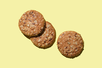 Dietary oatmeal cookies with  seeds on yellow background.