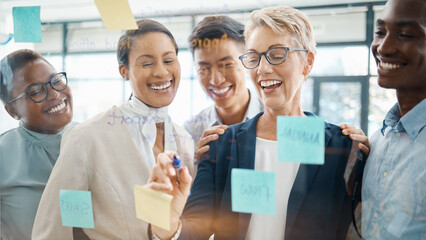 Teamwork, planning and strategy with a business woman, manager or CEO working with a team on a glass wall and sticky notes. Collaboration, learning or development with a group in an office for growth
