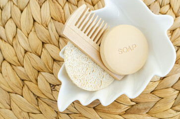 Bar of soap (solid shampoo), loofah bath sponge and wooden hair (beard) brush. Eco friendly toiletries set. Natural beauty treatment, skin care or zero waste concept. Top view, copy space.