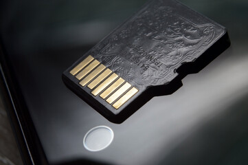micro sd card lies on the smartphone screen. close-up