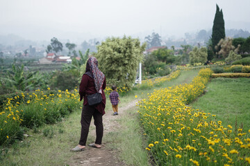 mother and daughter walking in the flower garden