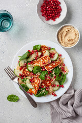healthy halloumi cheese and couscous salad with cucumber spinach pomegranate hummus