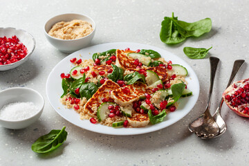 healthy halloumi cheese and couscous salad with cucumber spinach pomegranate hummus