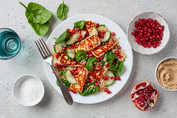 healthy halloumi cheese and couscous salad with cucumber spinach pomegranate hummus