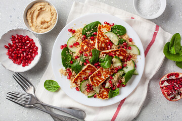 healthy halloumi cheese and couscous salad with cucumber spinach pomegranate hummus