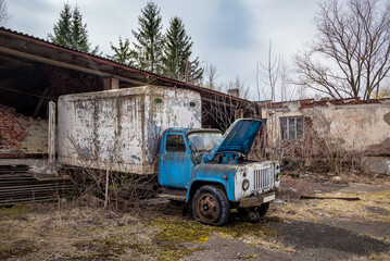 Fototapeta na wymiar Abandoned factory and rusty ruined truck