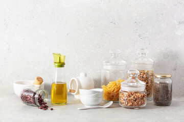 kitchen utensils on modern simple counter, kitchenware jars with dry ingredients bowls