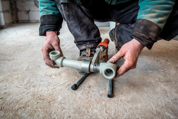 Work on the installation of heating or plumbing. Male plumber welding plastic pipes plumbing installation